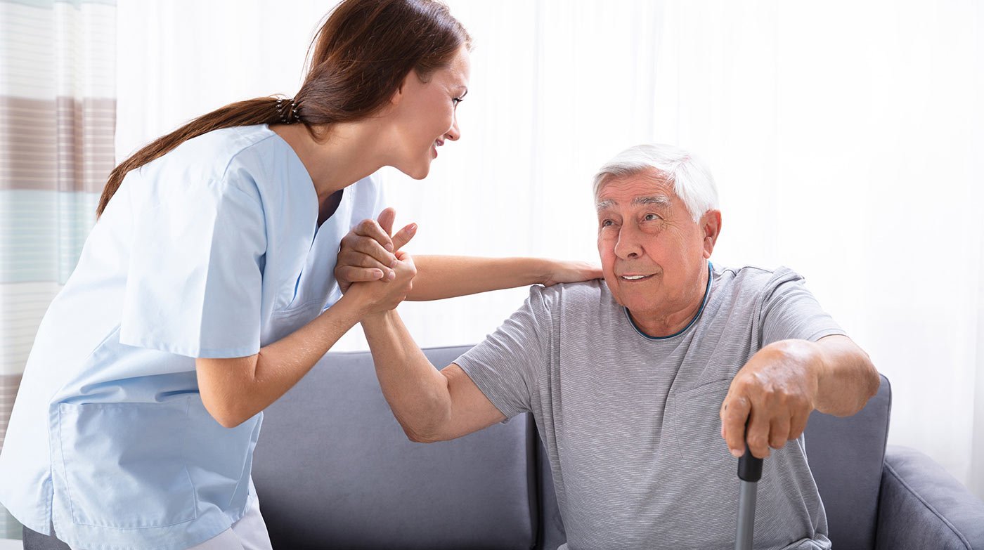 A home health aide assisting a senior at home