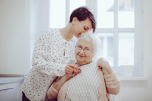 An adult daughter helping her senior mother at home